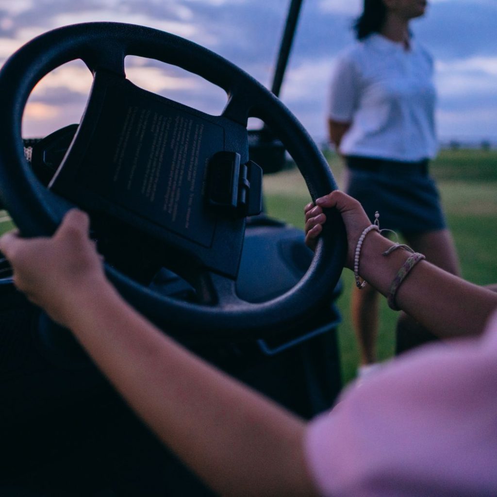 young woman driving a golf cart